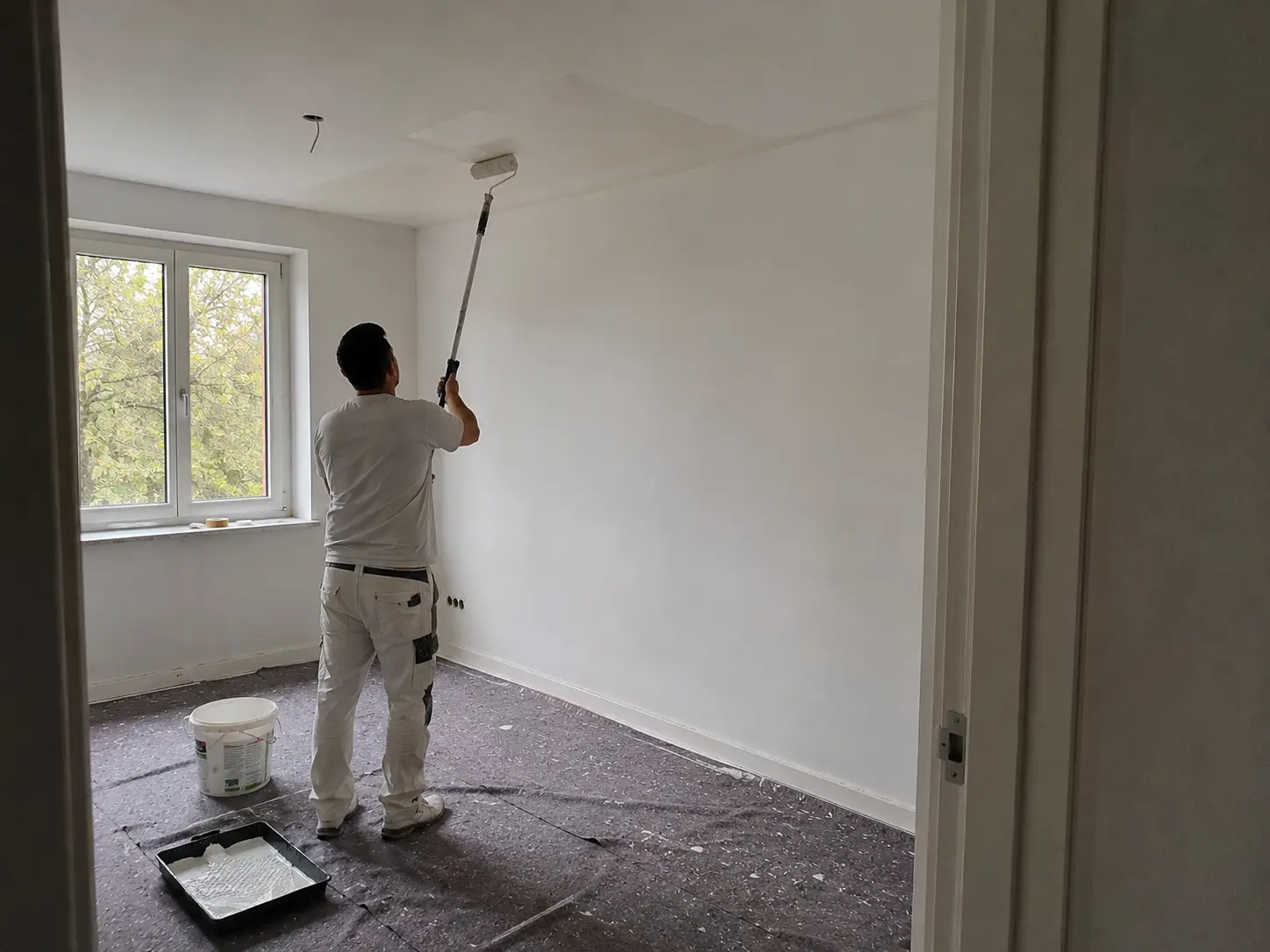 Maler bei der Arbeit beim Deckenanstrich in einem Wohnraum in Schwäbisch Hall