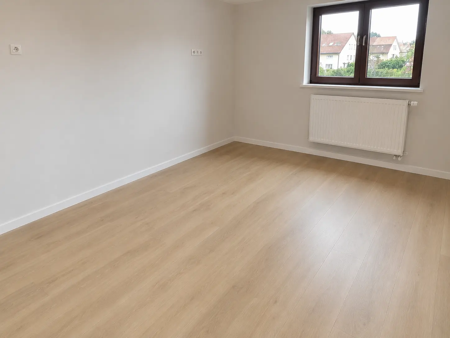 Wohnzimmer nach der kompletten Wohnungssanierung mit neuem Boden und frisch gestrichenen Wänden