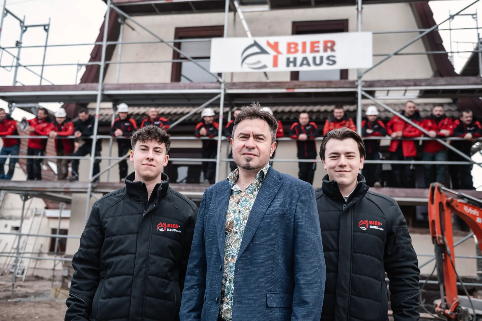 Führungsteam von Bier Haus vor Gerüst und Baustellenschild