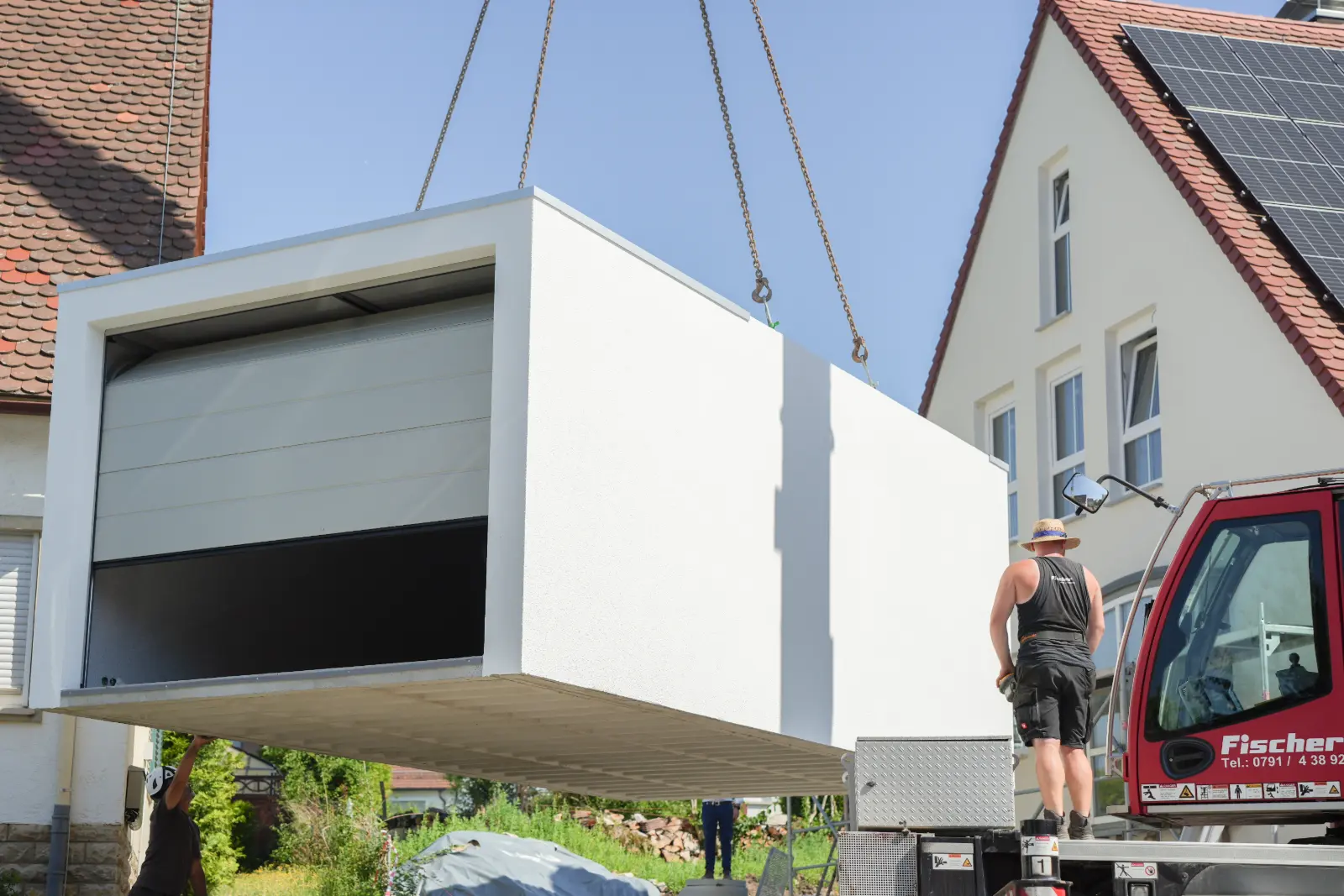 Fertiggarage am Kran wird neben einem Wohnhaus in Schwäbisch Hall abgesetzt