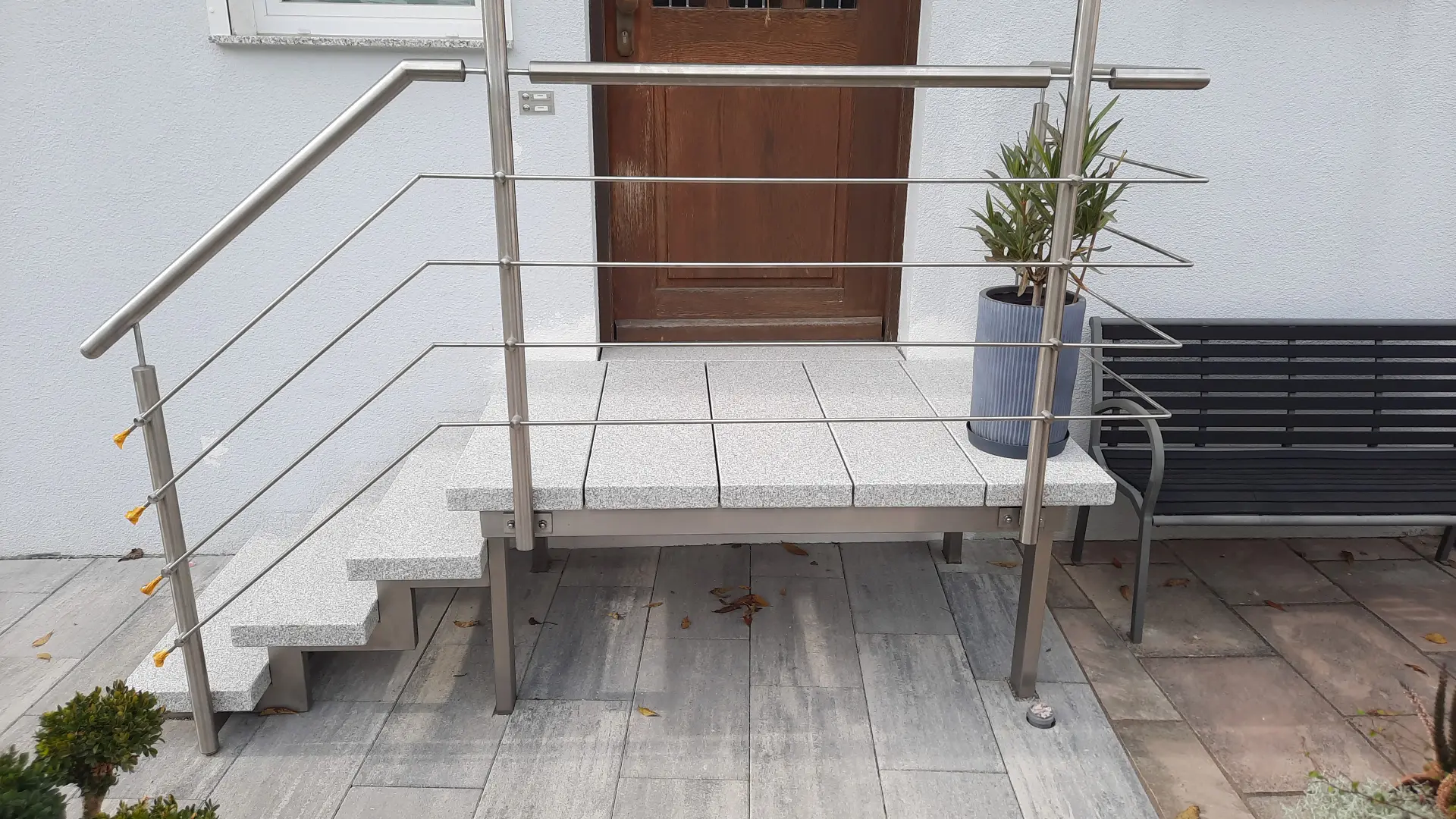 Aussentreppe mit Granitplatten und Edelstahlgeländer vor einem Hauseingang