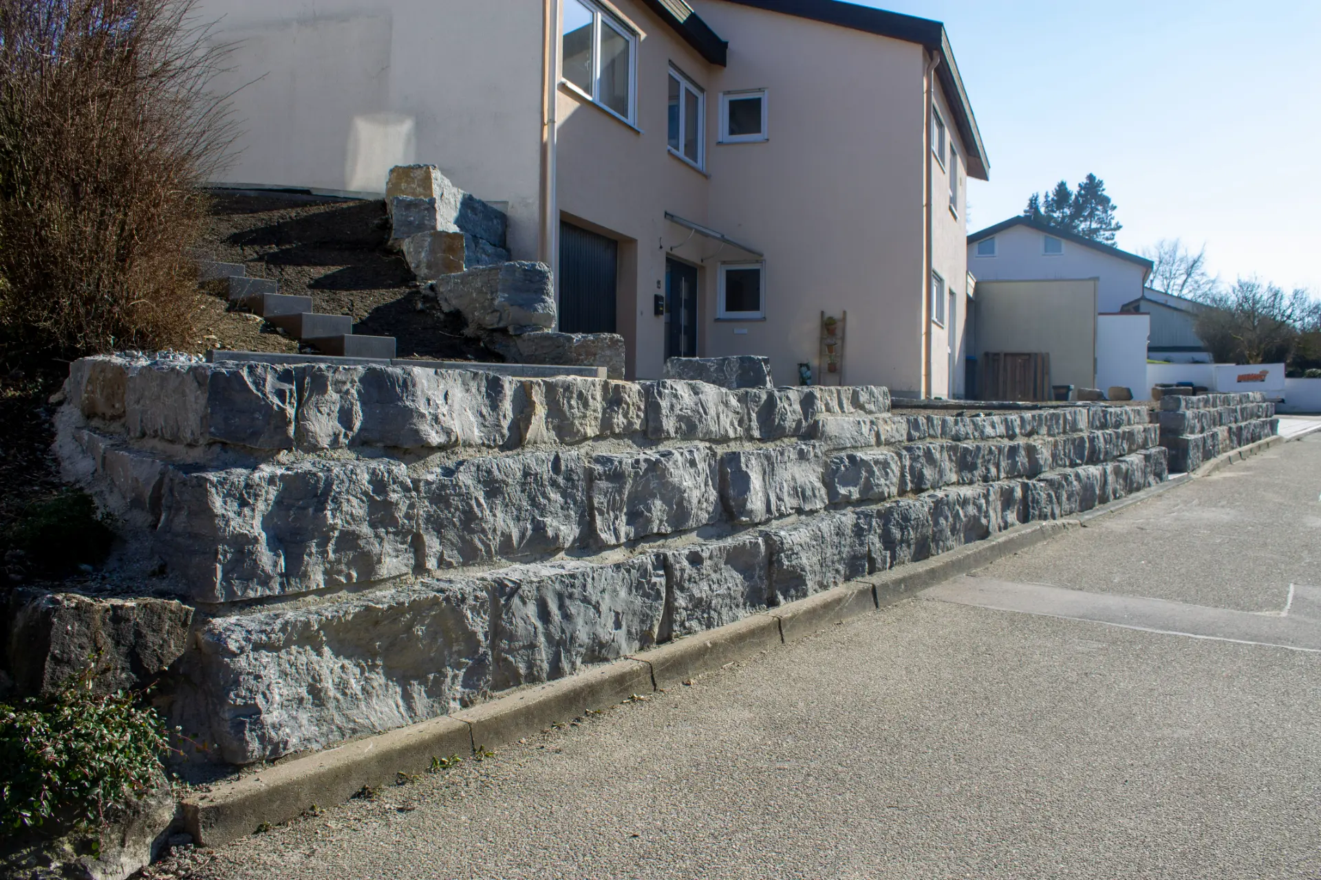 Mehrstufige Stützmauern aus Naturstein terrassieren einen Hang in Schwäbisch Hall