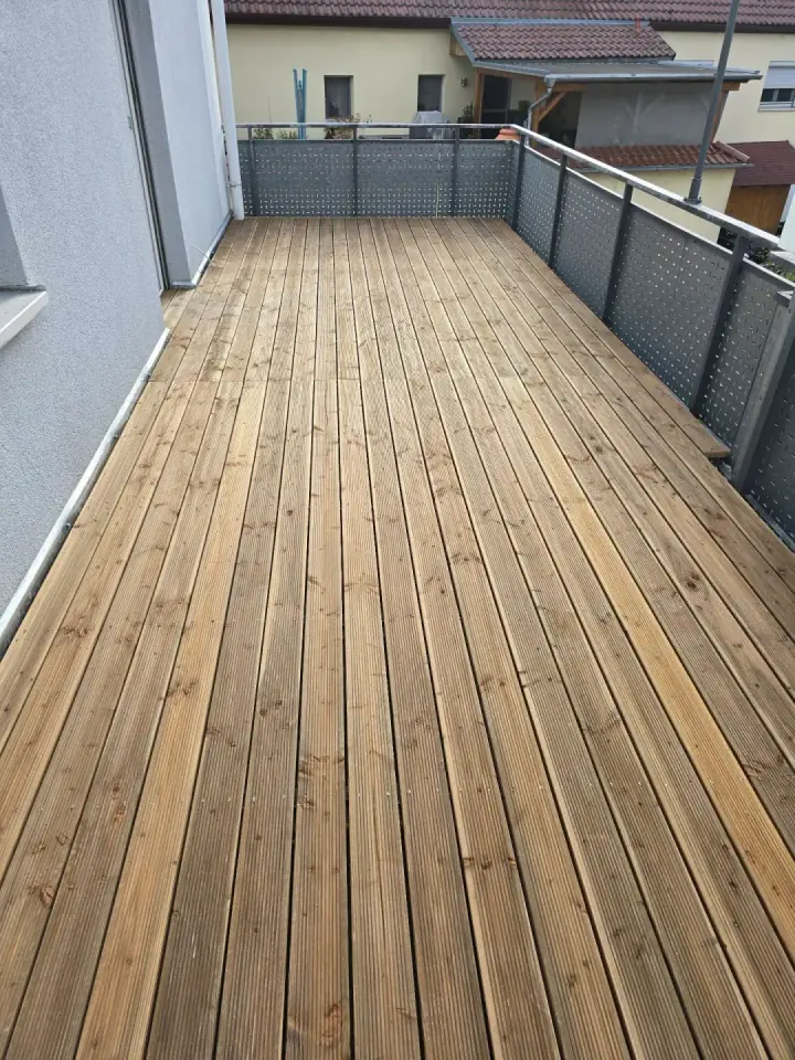 Fertig verlegte Holzdielen auf einem Balkon mit Lochblechgeländer in Schwäbisch Hall