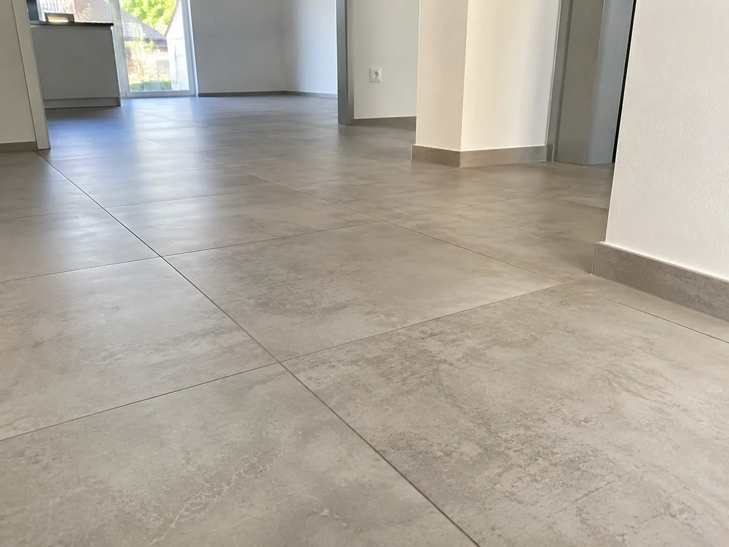 Großformatige Fliesen in Betonoptik im Flur und Wohnbereich eines sanierten Hauses in Schwäbisch Hall