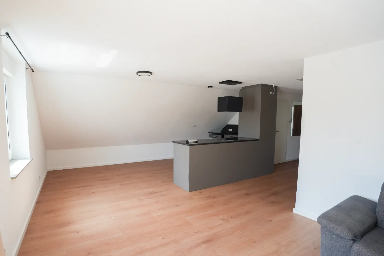 Fertig ausgebautes Dachgeschoss mit Küchenzeile, Holzboden und glatten Dachschrägen in Schwäbisch Hall