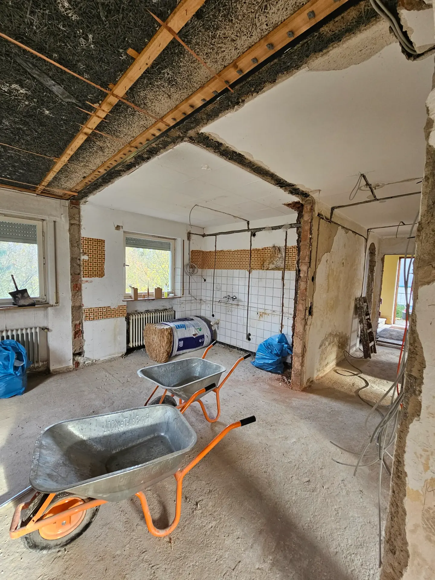 Entkernte Küche mit Schubkarren und geöffneter Decke zu Beginn einer Kernsanierung in Schwäbisch Hall
