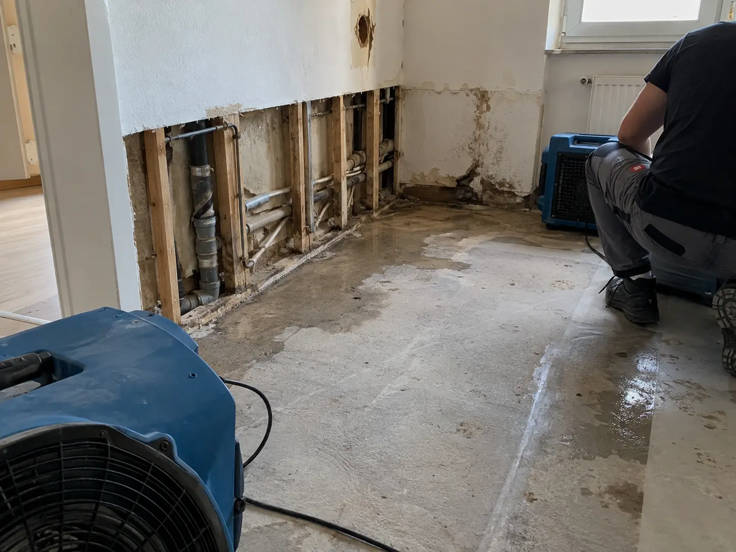 Wasserschaden mit geöffneter Wand, freigelegten Leitungen und Bautrocknern in Schwäbisch Hall