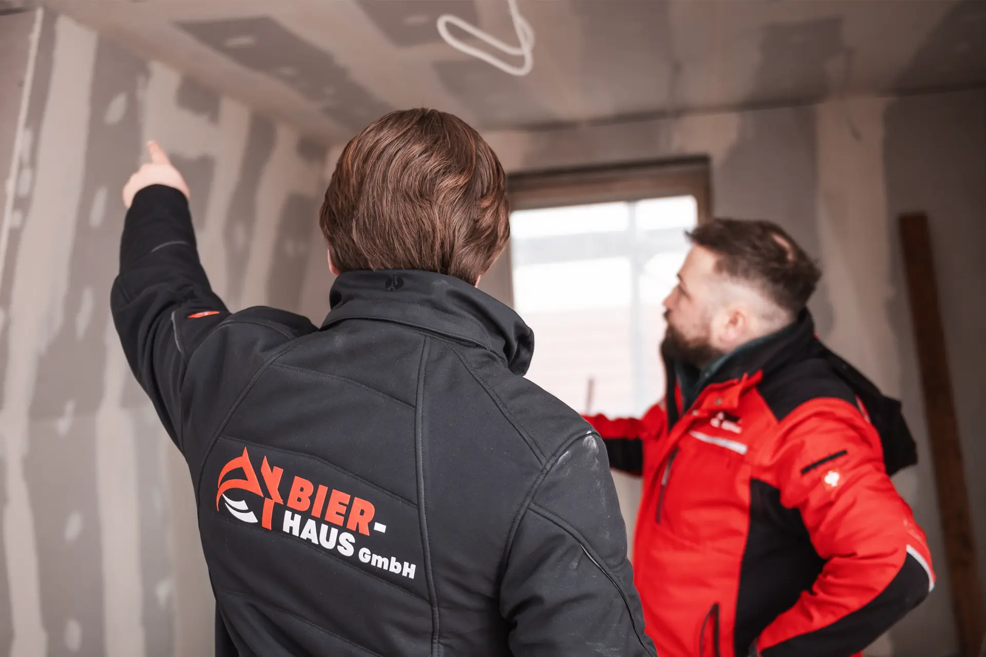 Zwei Mitarbeiter von Bier Haus besprechen auf der Baustelle die Arbeiten an der Decke