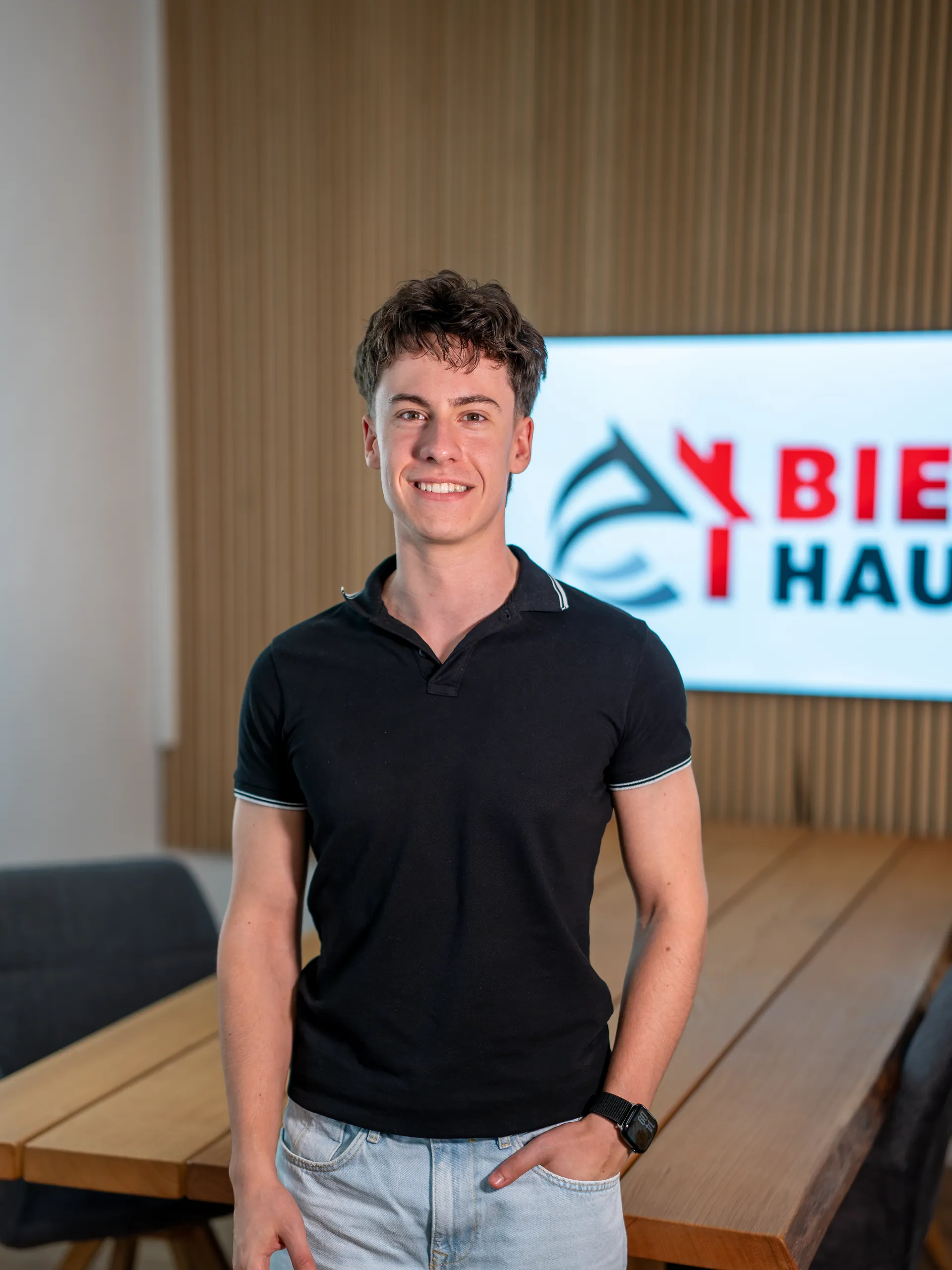 David Bier im Büro von Bier Haus in Schwäbisch Hall vor Holzlamellen und dem Firmenlogo