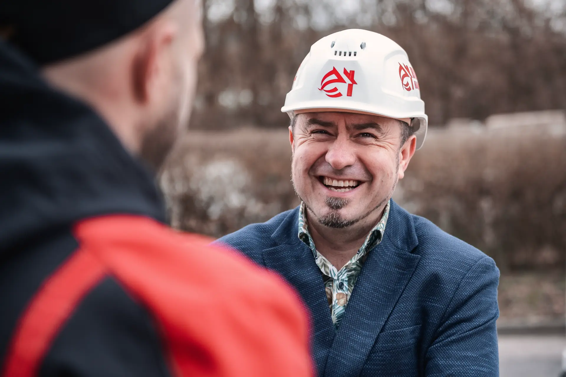 Eduard Bier mit Schutzhelm, lachend auf der Baustelle