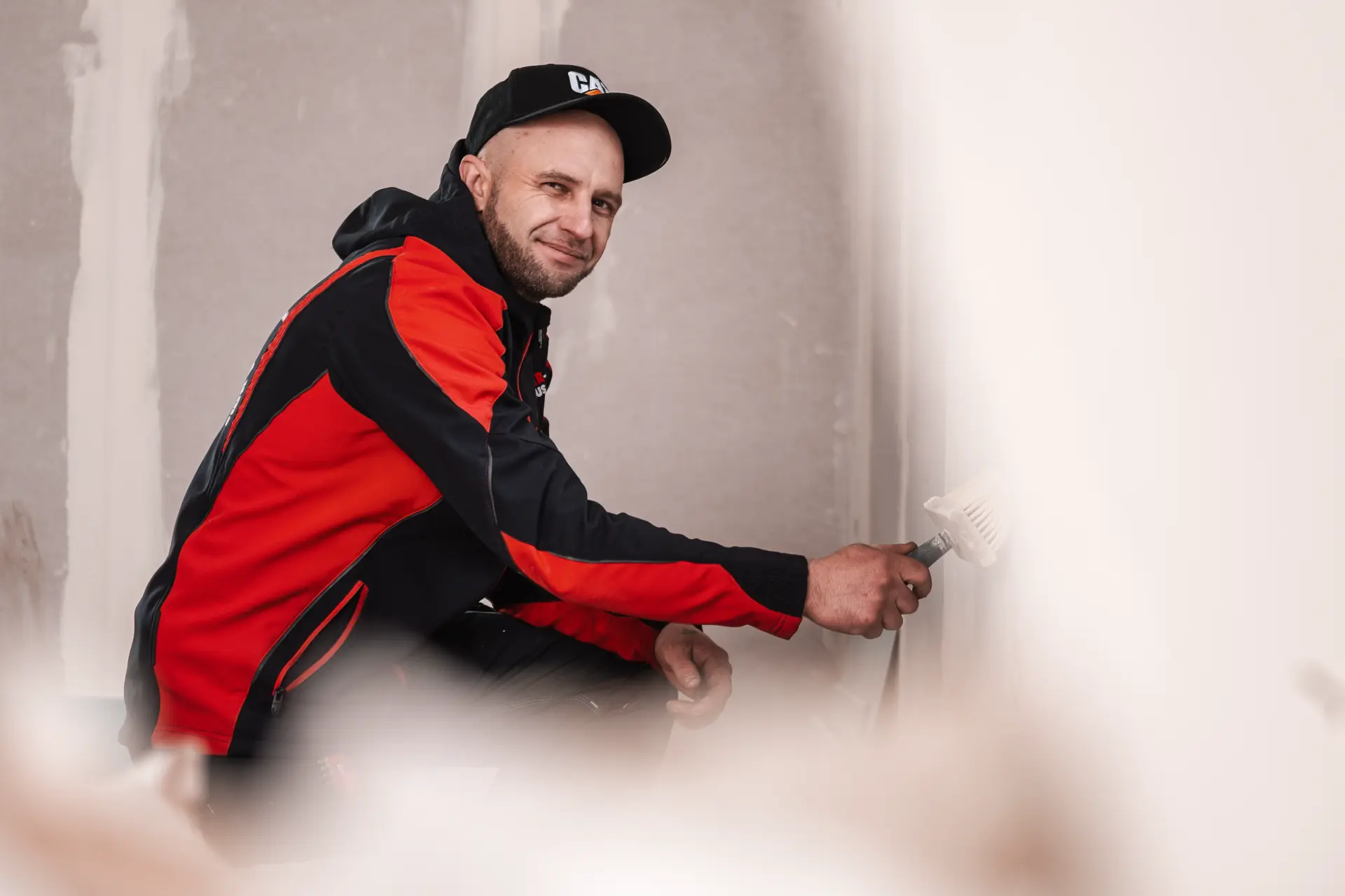 Handwerker von Bier Haus spachtelt eine Wand im Innenausbau