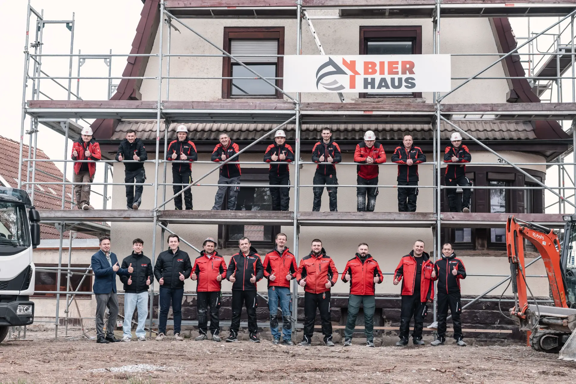 Team von Bier Haus vor dem Gerüst mit erhobenem Daumen